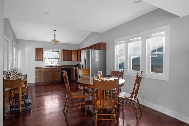 dining space featuring dark hardwood / wood-style flooring, sink, and vaulted ceiling