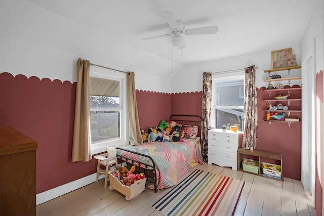 bedroom with light hardwood / wood-style floors, vaulted ceiling, and ceiling fan