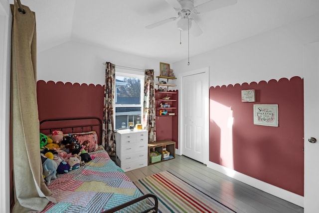 bedroom featuring ceiling fan, light wood-type flooring, and lofted ceiling