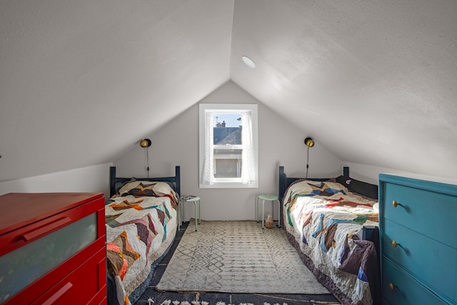 carpeted bedroom with a textured ceiling and vaulted ceiling