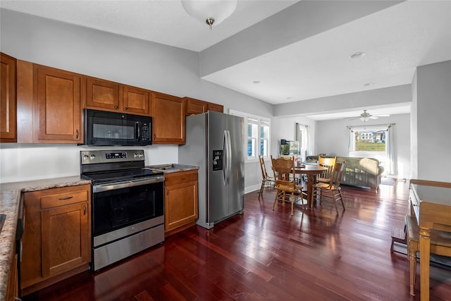 kitchen with appliances with stainless steel finishes, dark hardwood / wood-style flooring, and ceiling fan