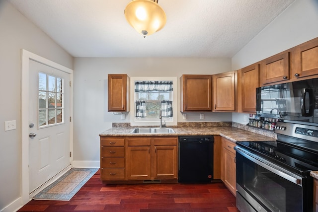 kitchen featuring black appliances, dark hardwood / wood-style floors, sink, and a textured ceiling