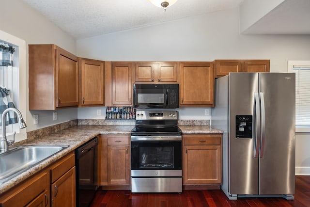 kitchen featuring sink, dark hardwood / wood-style floors, lofted ceiling, a textured ceiling, and black appliances