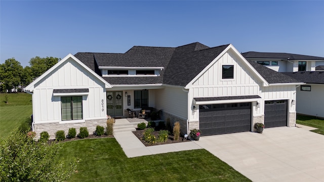 modern farmhouse with a front yard, a porch, and a garage