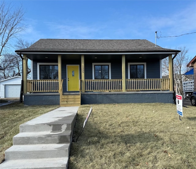 view of front of property with a garage, covered porch, an outbuilding, and a front lawn