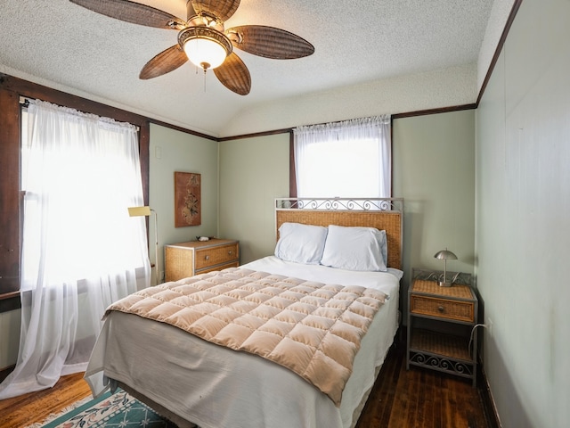 bedroom featuring a textured ceiling, dark hardwood / wood-style floors, vaulted ceiling, and ceiling fan