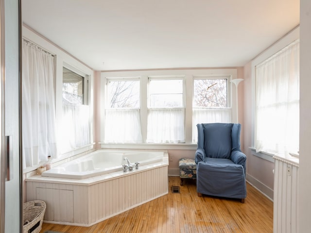 sitting room with light hardwood / wood-style floors, radiator, and a wealth of natural light