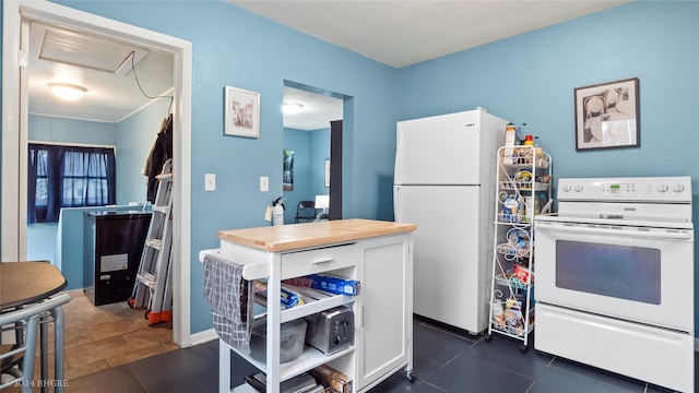 kitchen featuring white cabinets, white appliances, dark tile patterned floors, and butcher block countertops