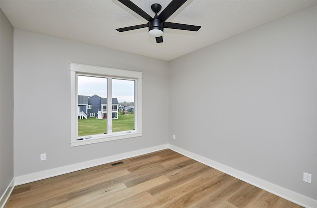 spare room featuring visible vents, baseboards, light wood-style floors, and ceiling fan