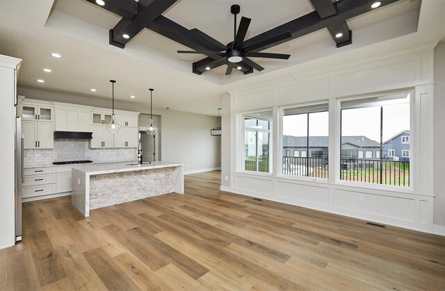 kitchen with decorative backsplash, white cabinetry, coffered ceiling, under cabinet range hood, and recessed lighting