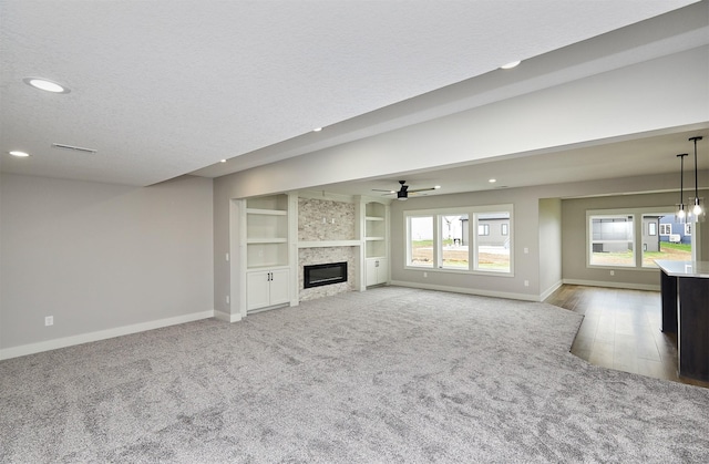 unfurnished living room with a tile fireplace, baseboards, recessed lighting, and carpet flooring