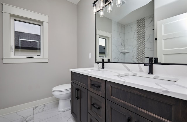 bathroom featuring marble finish floor, baseboards, toilet, and a sink