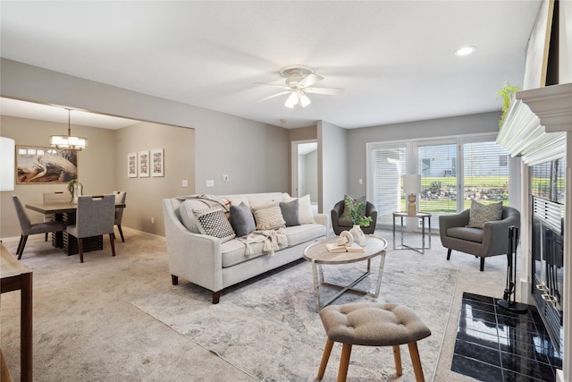 living room featuring light carpet and ceiling fan with notable chandelier