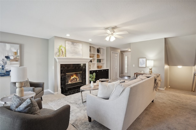 living room with a tiled fireplace, light carpet, and ceiling fan