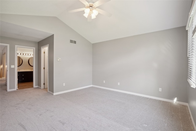 unfurnished bedroom with ensuite bathroom, ceiling fan, light carpet, and lofted ceiling