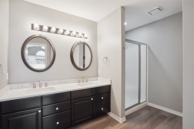 bathroom featuring vanity, an enclosed shower, and hardwood / wood-style flooring