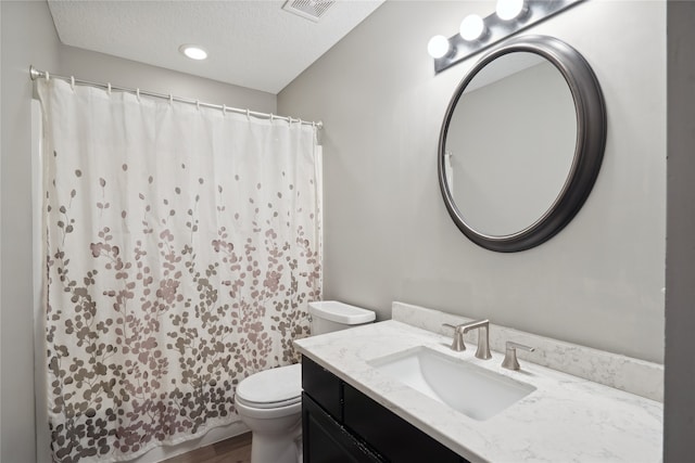 bathroom featuring a textured ceiling, vanity, toilet, and wood-type flooring