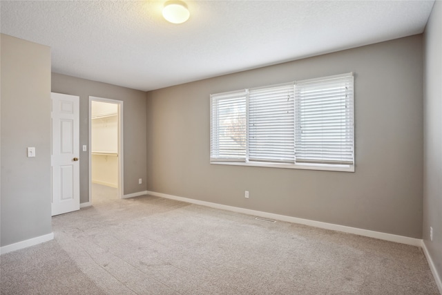 unfurnished room with light carpet and a textured ceiling