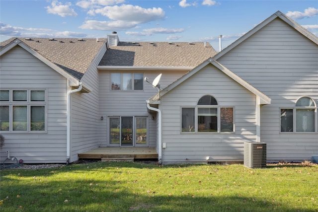 back of property with a yard and central AC