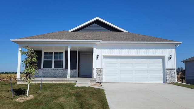 view of front of property with a garage, covered porch, a front yard, stone siding, and driveway