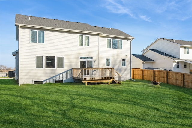 back of property with a lawn, central AC unit, and a wooden deck