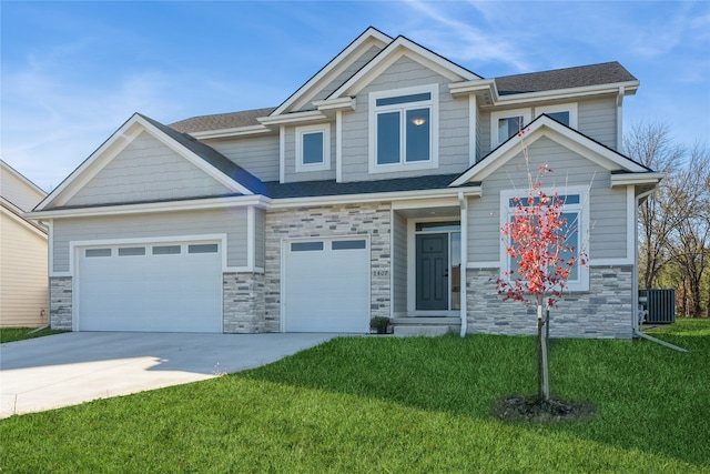 craftsman inspired home with a garage, central air condition unit, and a front lawn