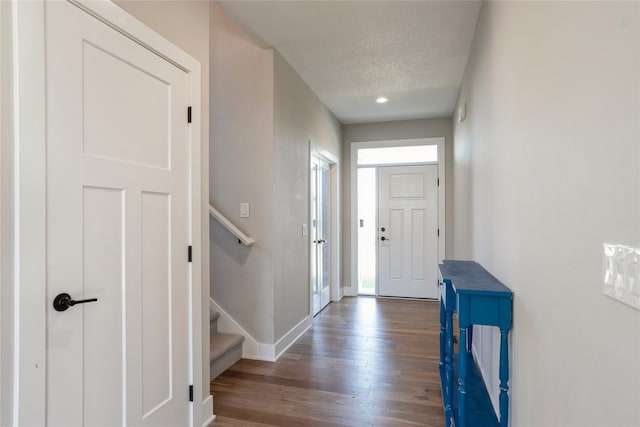 foyer entrance featuring dark hardwood / wood-style flooring and a textured ceiling