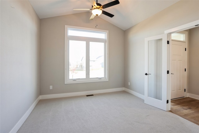 carpeted empty room featuring ceiling fan and lofted ceiling