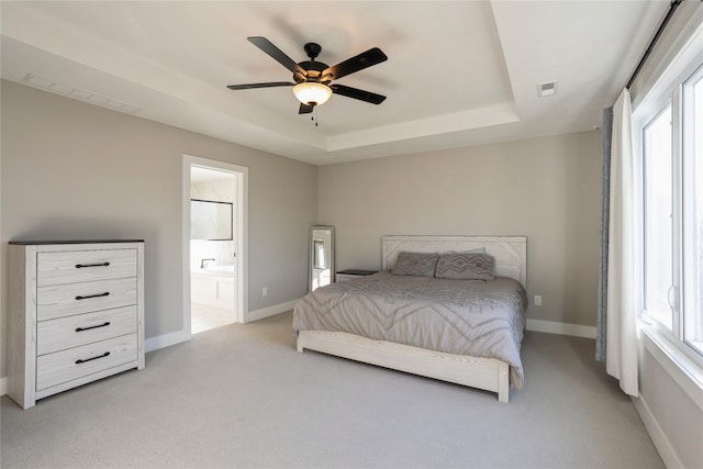 carpeted bedroom with ceiling fan, sink, connected bathroom, and a tray ceiling