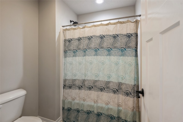 bathroom featuring curtained shower and toilet