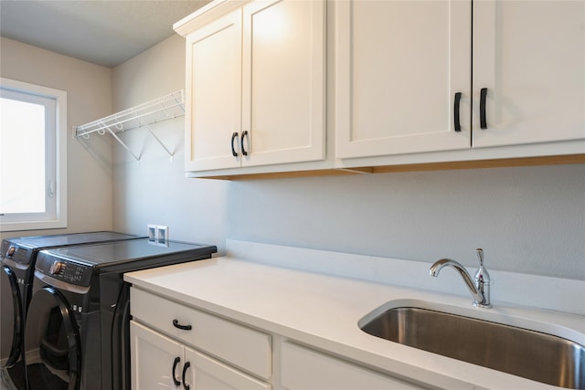 laundry room with washer and clothes dryer, sink, and cabinets