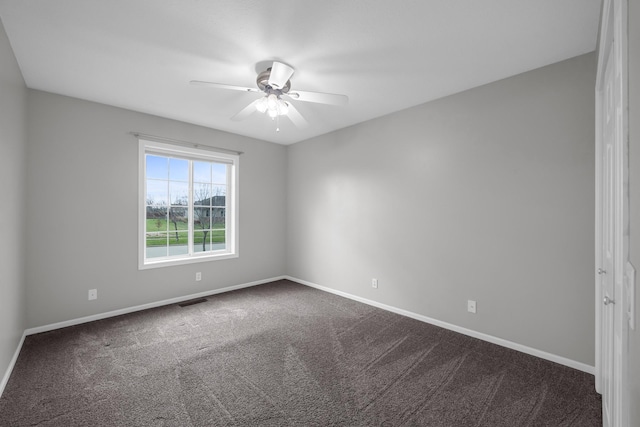 empty room featuring ceiling fan and dark carpet