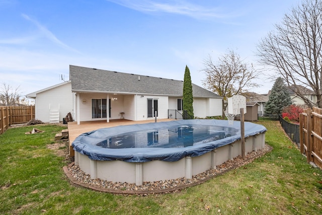 back of property with a pool side deck, a shed, and a yard