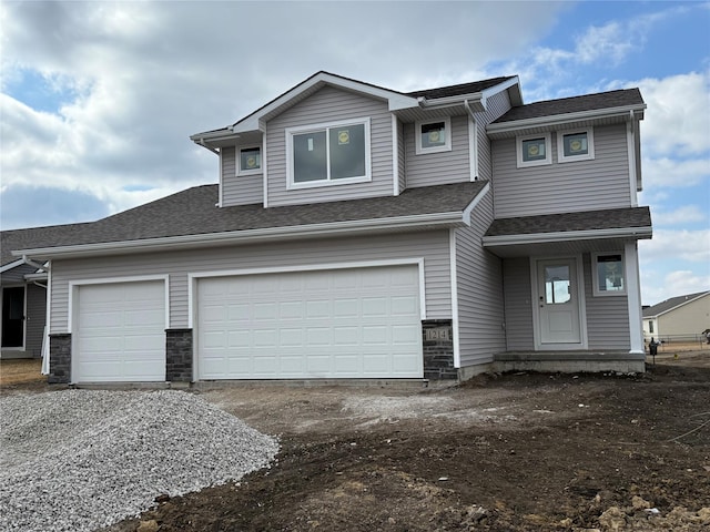 view of front of house featuring a shingled roof and driveway