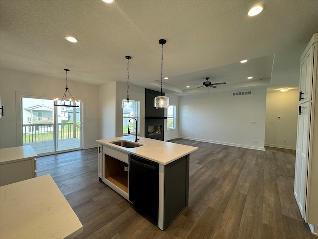 kitchen with white cabinets, sink, black dishwasher, an island with sink, and dark hardwood / wood-style flooring