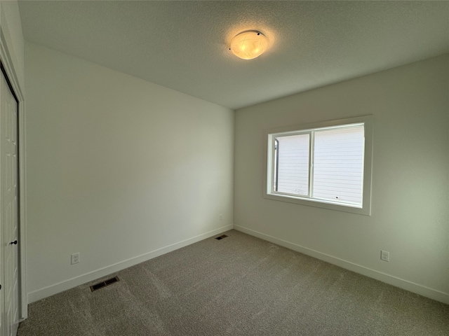 carpeted spare room featuring a textured ceiling