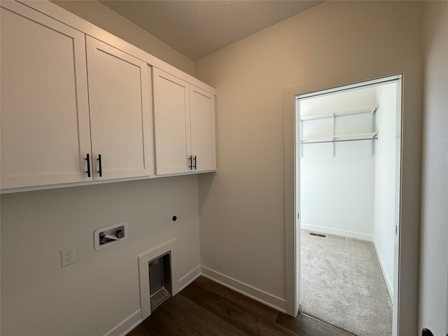 clothes washing area with cabinets, electric dryer hookup, dark hardwood / wood-style floors, hookup for a washing machine, and a textured ceiling