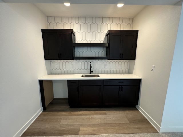 kitchen featuring light hardwood / wood-style floors, sink, and tasteful backsplash