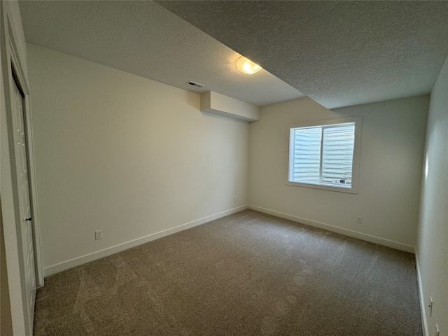 carpeted empty room with a textured ceiling