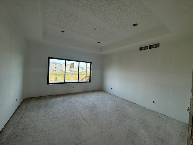 spare room with a tray ceiling