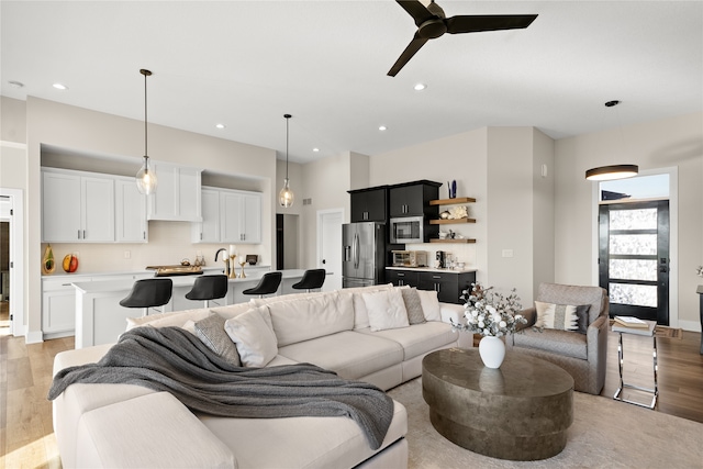 living room with recessed lighting, light wood-type flooring, and ceiling fan