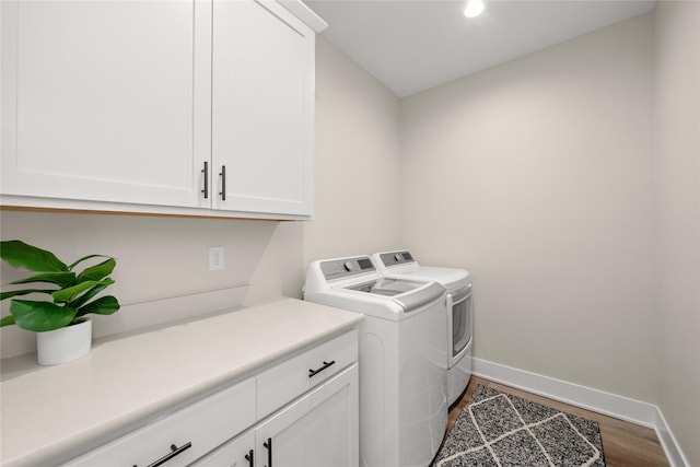 laundry room with washer and clothes dryer, cabinet space, baseboards, and wood finished floors