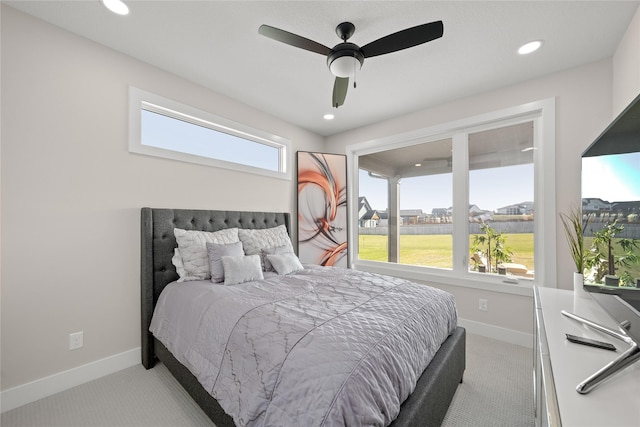 bedroom with multiple windows, baseboards, and light carpet