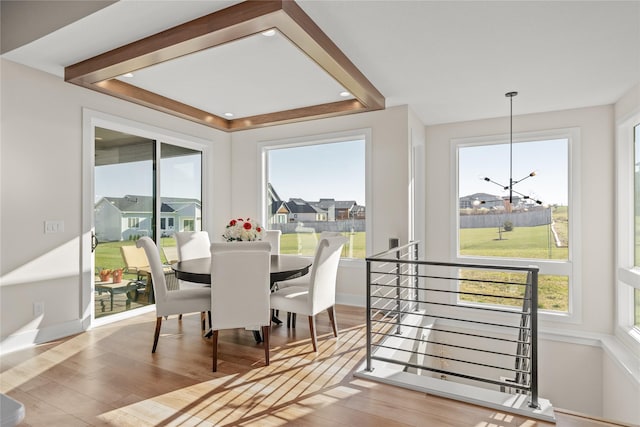 dining area featuring a notable chandelier, baseboards, and wood finished floors