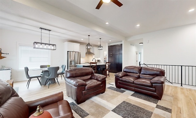 living room with light hardwood / wood-style flooring and ceiling fan