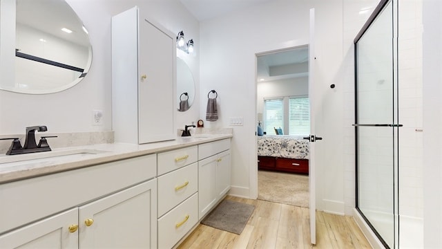 bathroom featuring wood-type flooring, vanity, and walk in shower