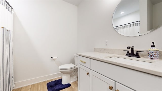 bathroom with hardwood / wood-style flooring, vanity, and toilet