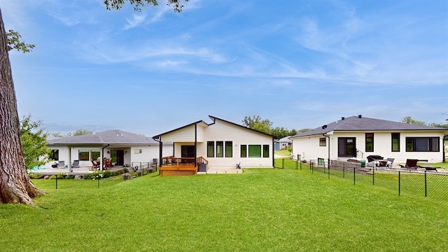 back of house featuring a lawn and a wooden deck