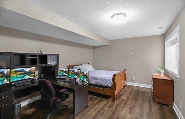 bedroom featuring a textured ceiling and dark hardwood / wood-style floors