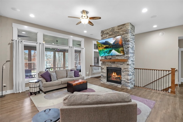 living room featuring a fireplace, hardwood / wood-style floors, and ceiling fan